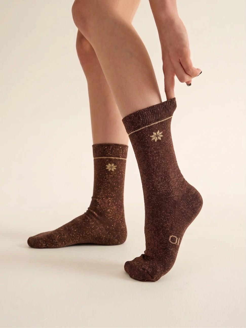 Par de calcetines chocolate con hilo lurex eleOnora puestos, mostrando el brillo del tejido en las piernas